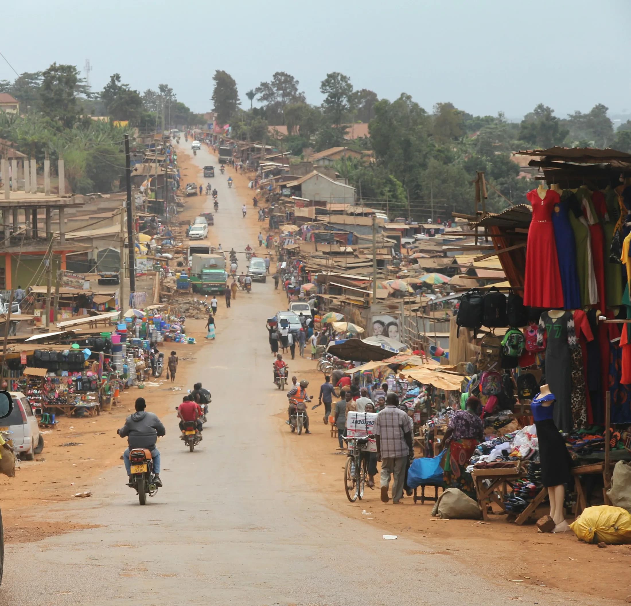 Colourful street market with traders and motorbikes