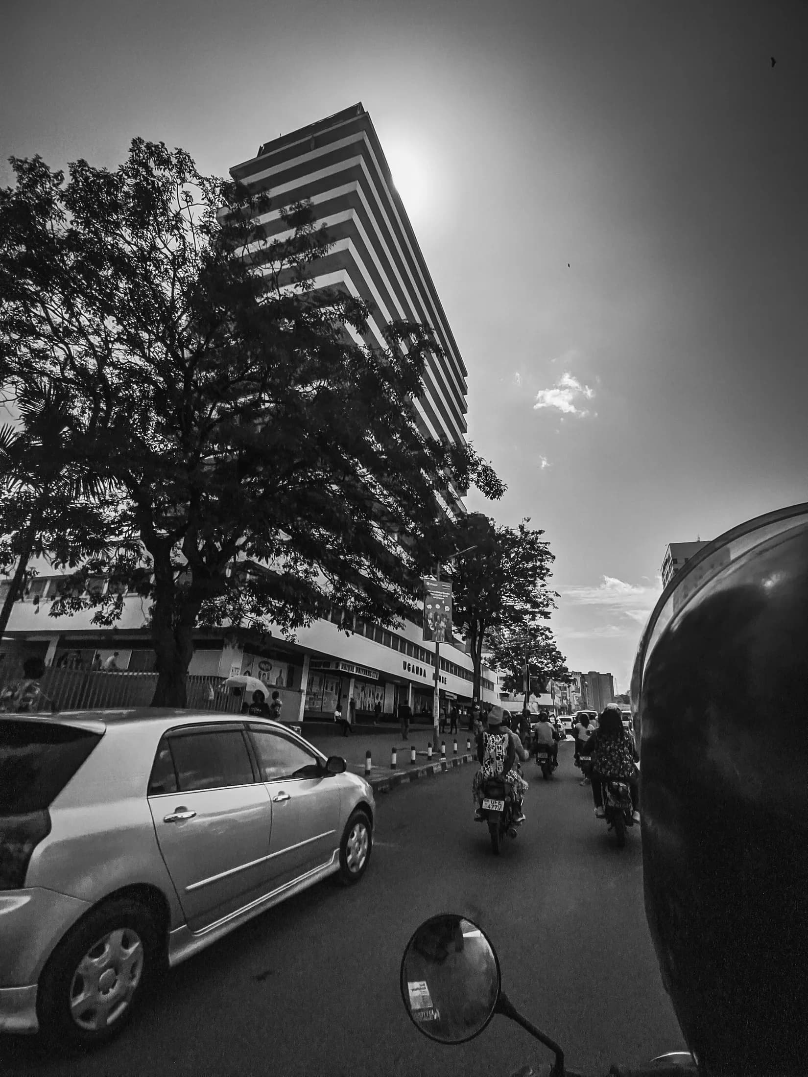 Black-and-white view of a Ugandan street and its buildings