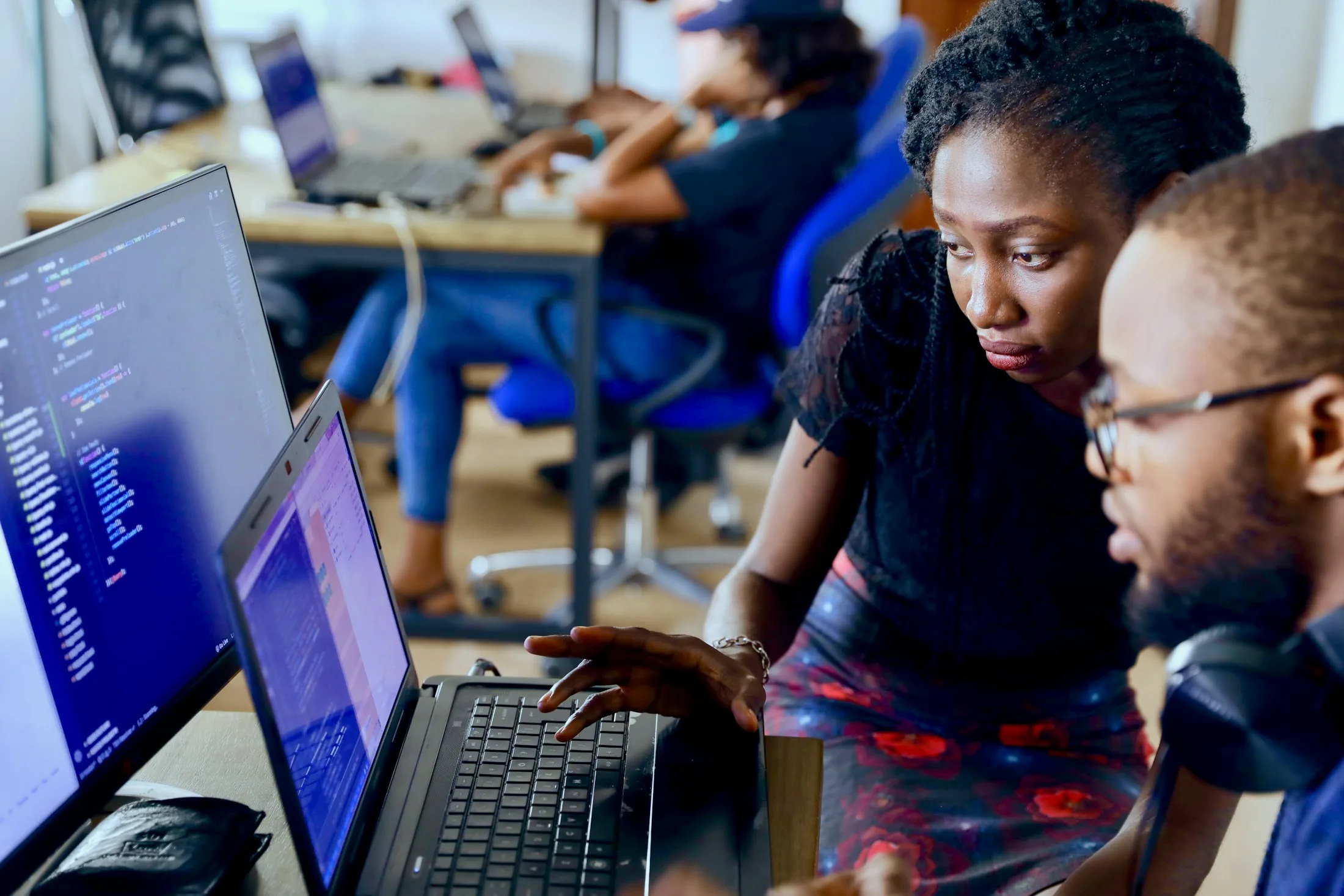 Two team members reviewing drawings on a laptop in a studio